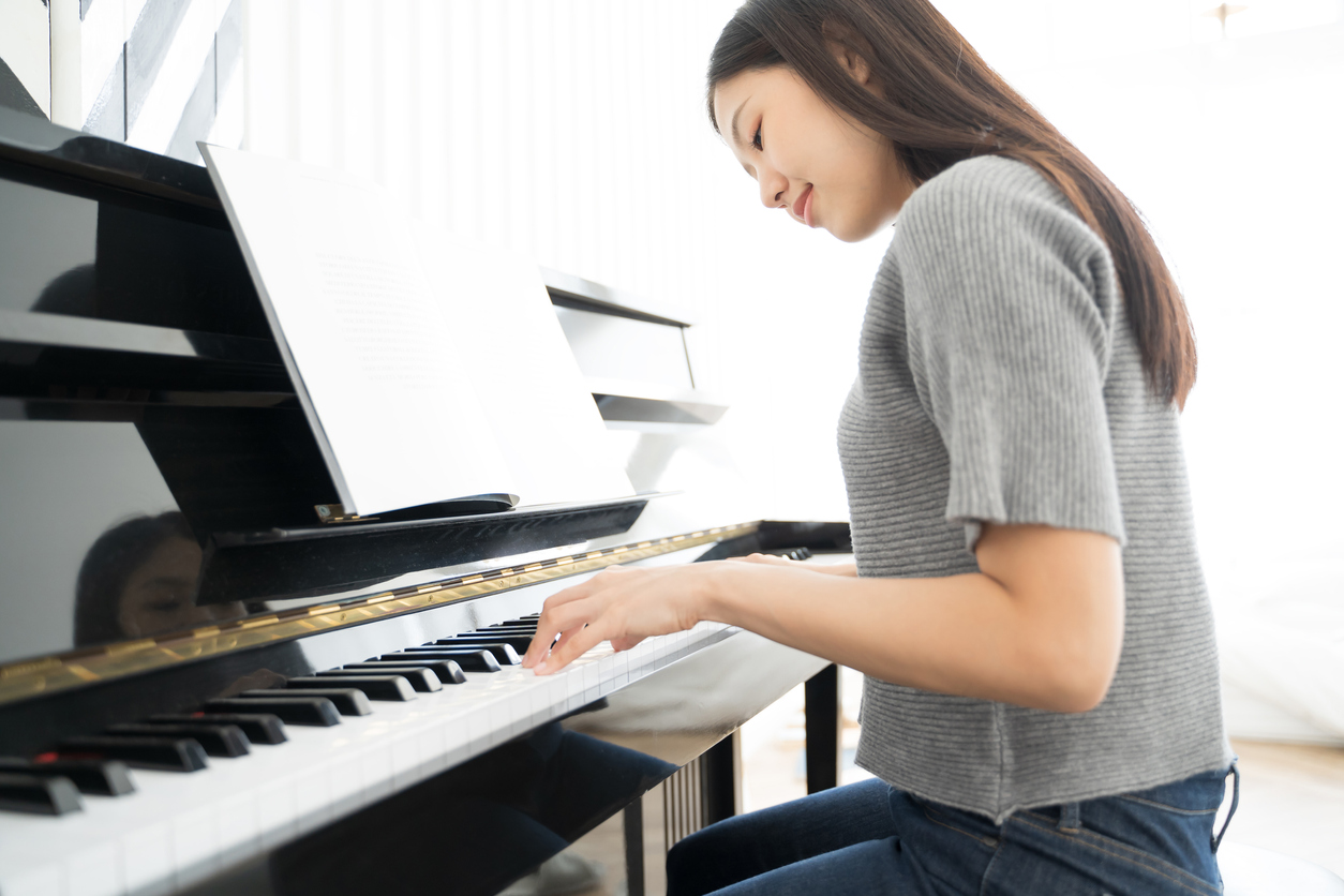 Portrait Asian woman playing  playing piano